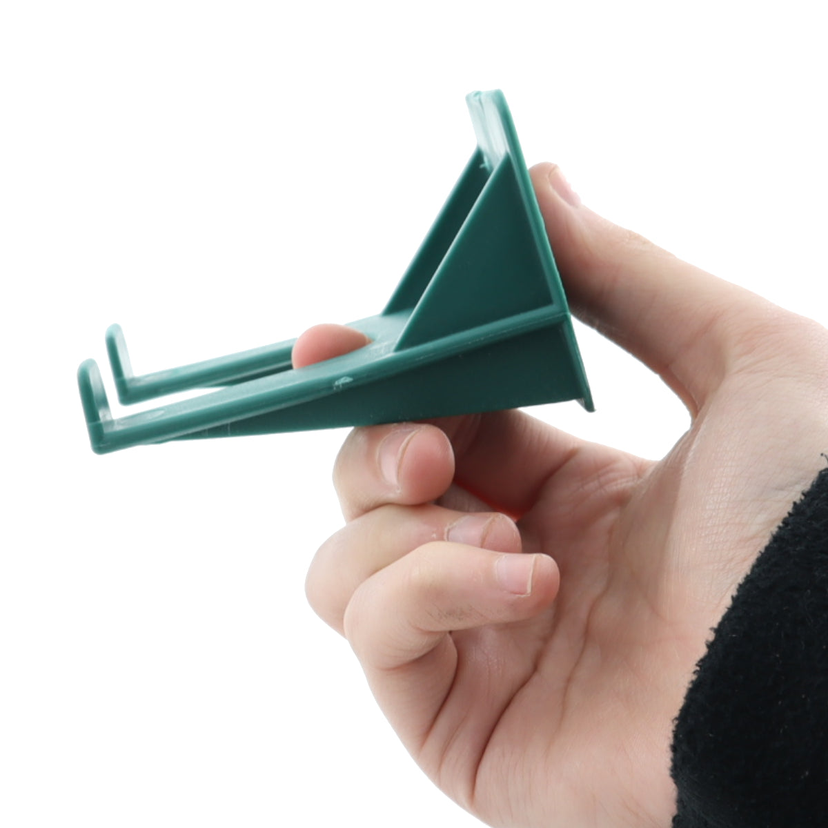 Hand holding a green plastic tool against a white background