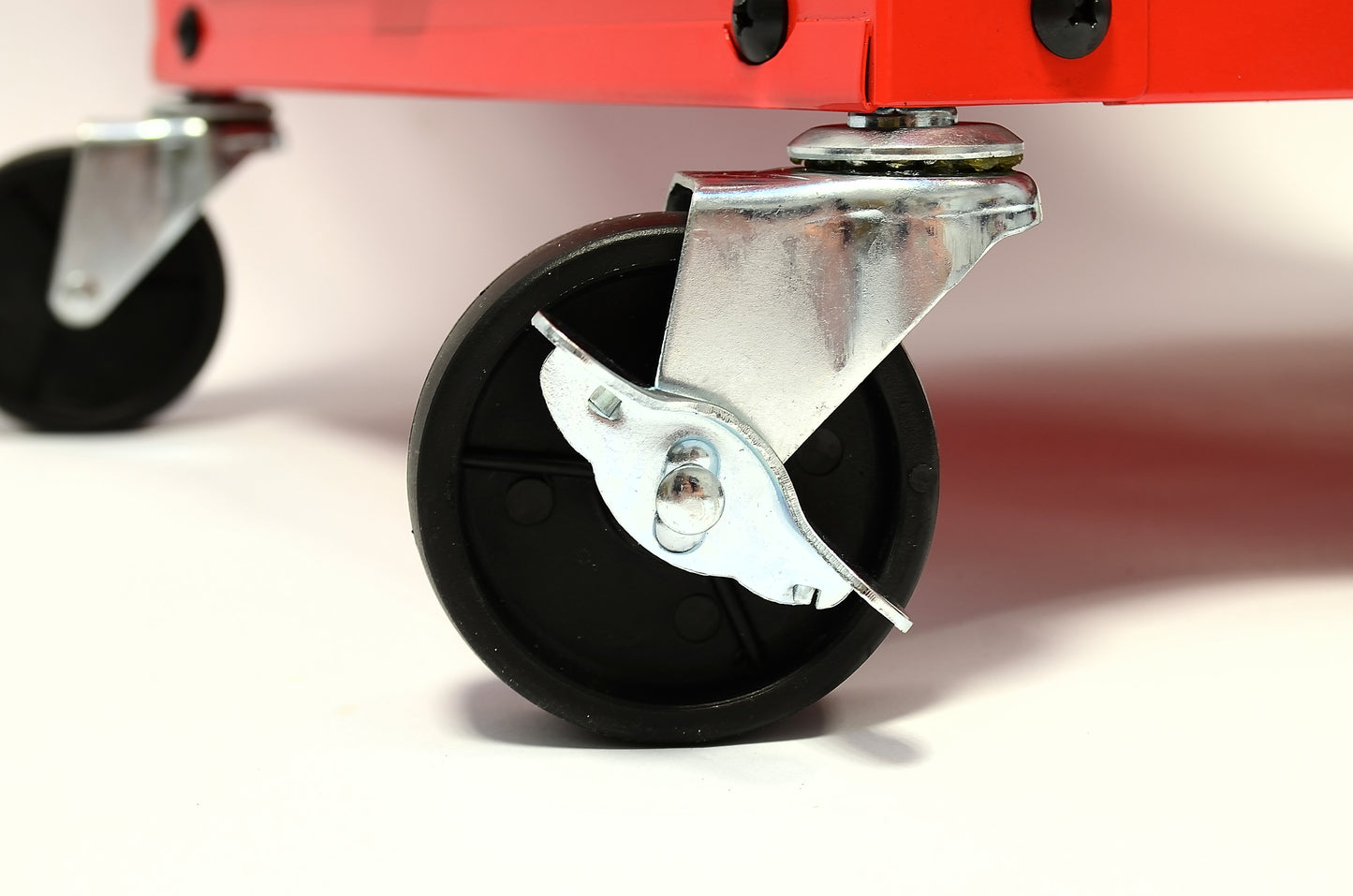 Close-up of a black wheel with a metal brake on a white background