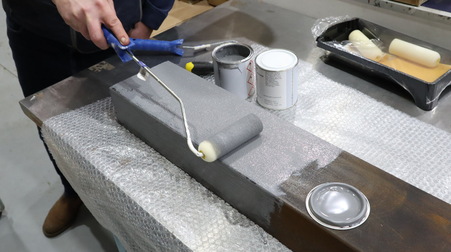 Person preparing paint tools on a textured surface.