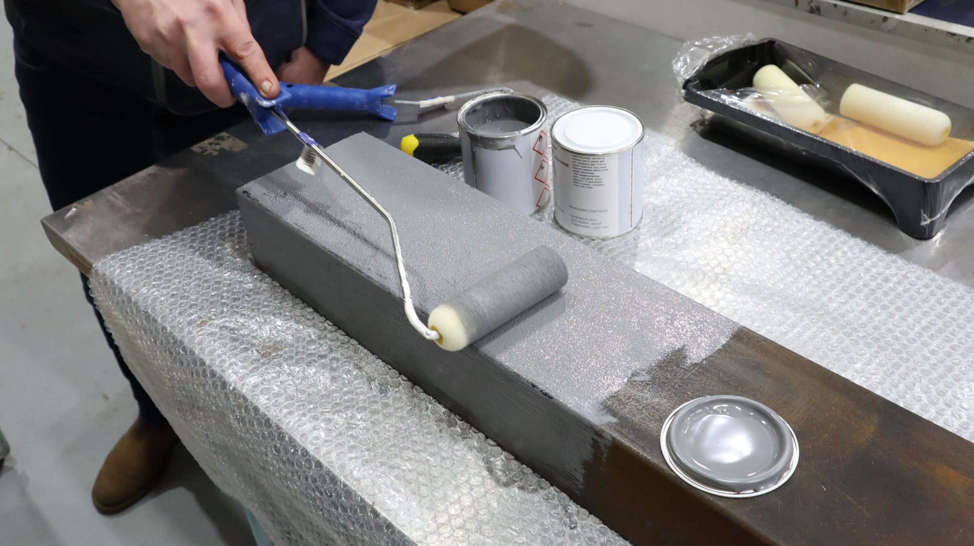 Person preparing paint tools on a textured surface.