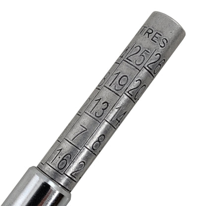 Metal tire pressure gauge with numerical markings on a white background