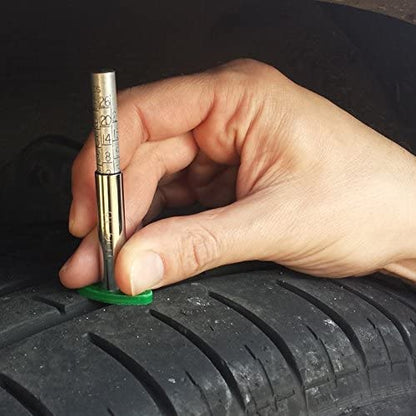 Person using a tire pressure gauge on a car tire