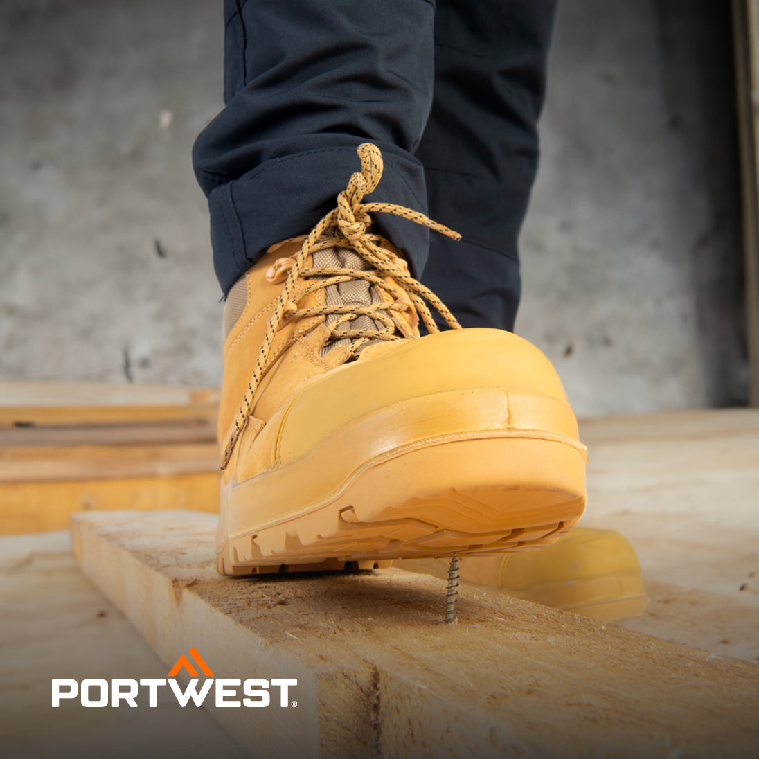 Yellow work boot on a wooden surface with 'Portwest' branding.