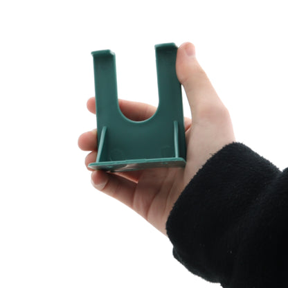 Hand holding a green plastic tool on a white background