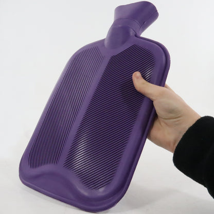 Purple hot water bottle held by a hand on a white background
