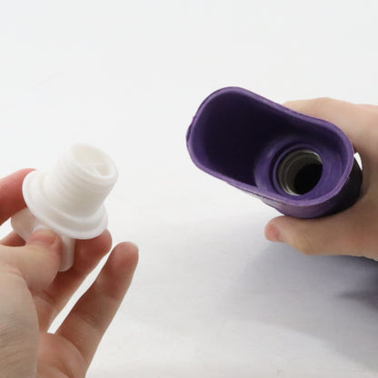 White and purple silicone bottle stoppers held by hands on a light gray background